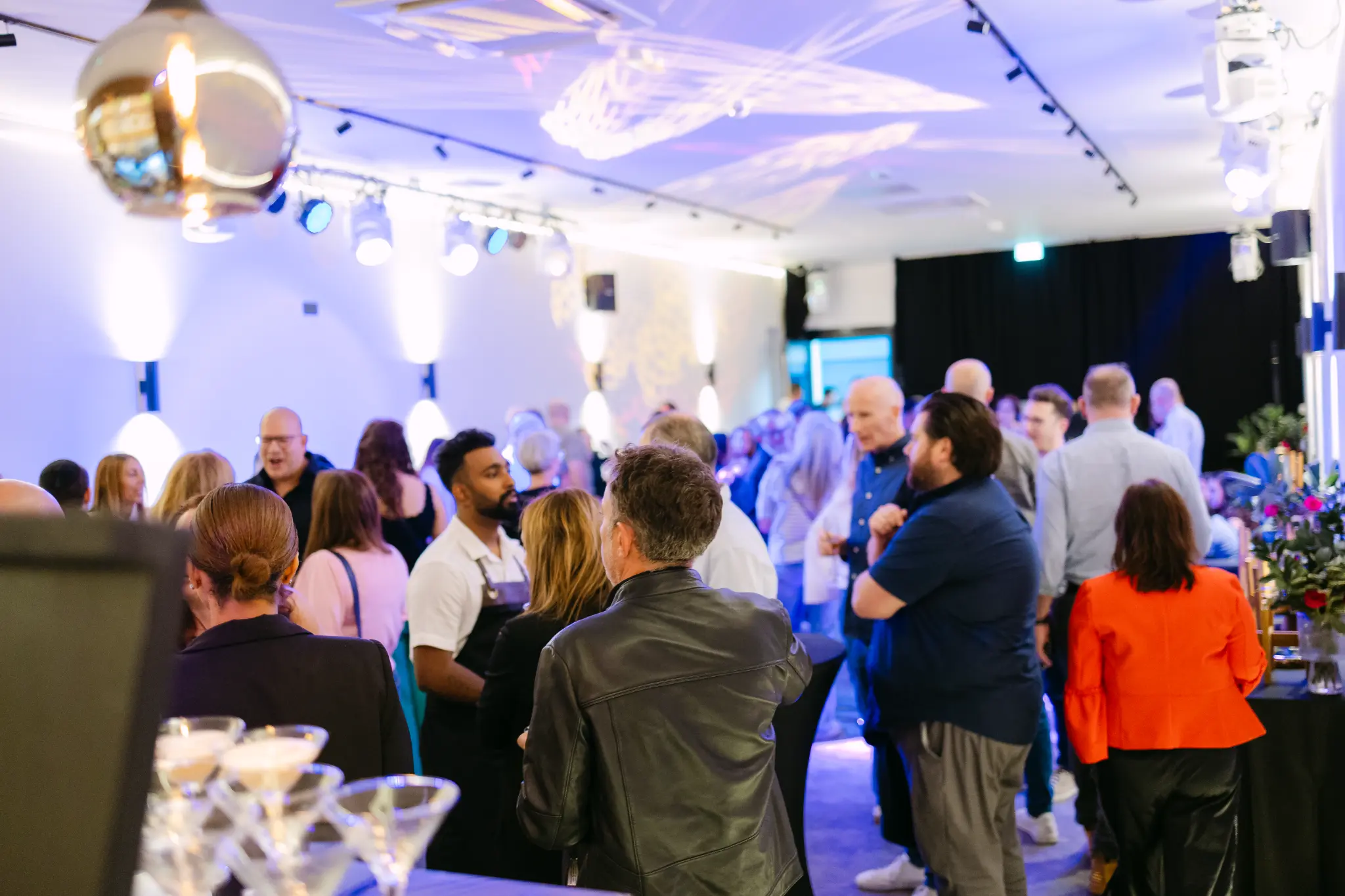 Guests gathered beneath the venue's lighting rig